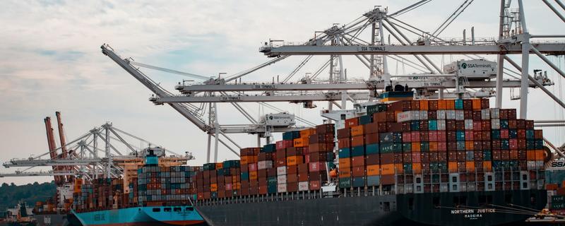 Container ships being worked under ship-to-shore cranes at a port