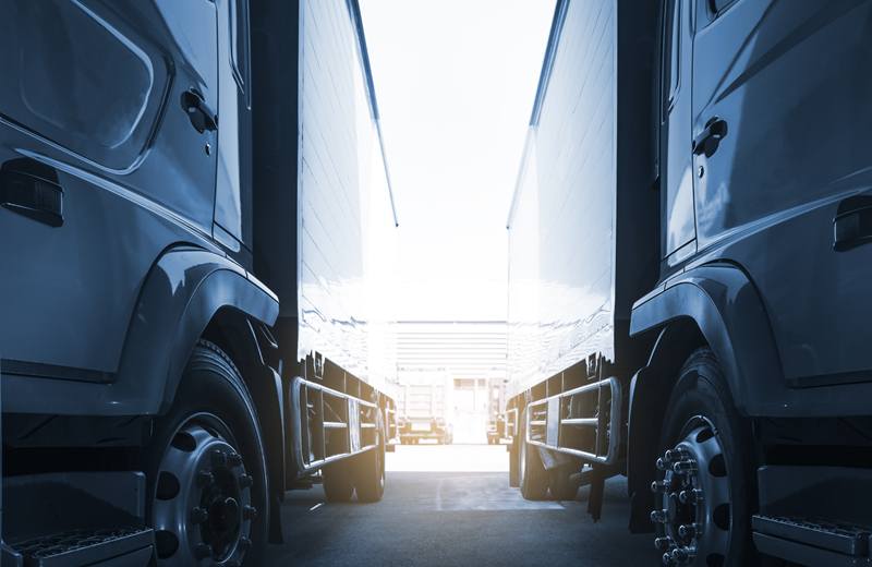 Row of freight trucks parked side by side at a depot
